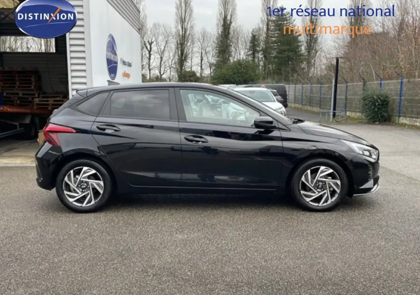 Profil côté gauche d'une Hyundai i20 2025 noire Phantom Metal, avec jantes alliage et lignes modernes visibles.