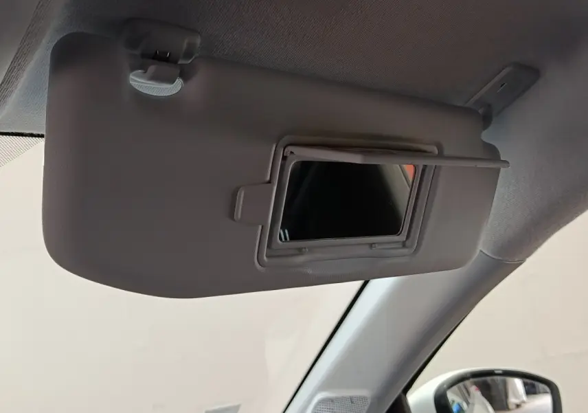Détail de pare-soleil avec miroir intégré côté conducteur dans l'habitacle d'une Peugeot 208 blanche.