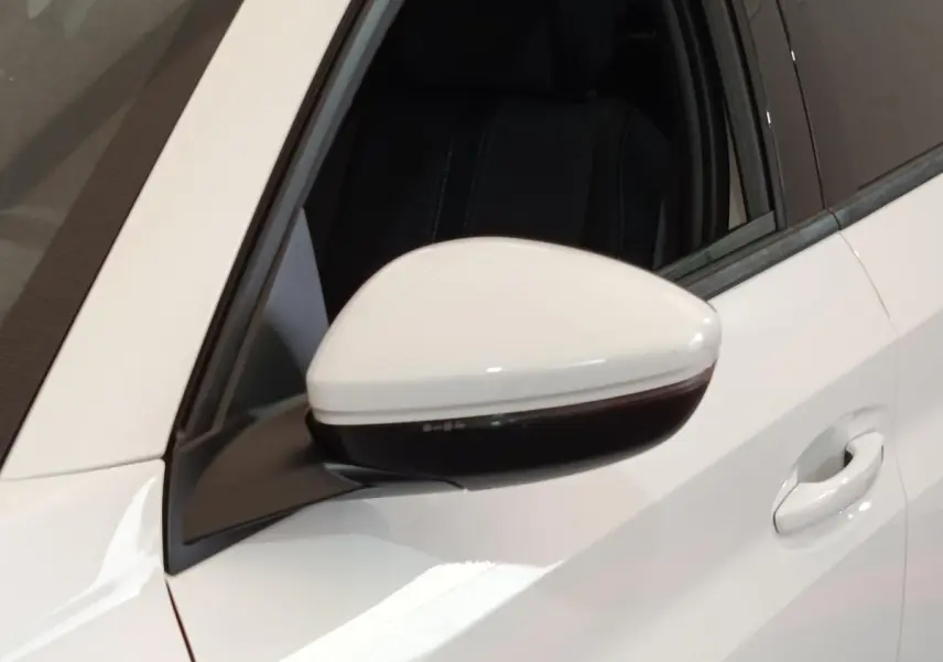 Rétroviseur côté gauche blanc de Peugeot 208 PureTech 100 S&S Allure Business 2021 avec poignée de porte assortie.