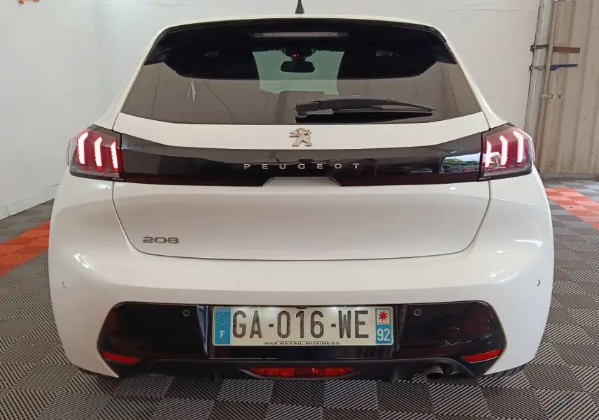 Vue arrière d'une Peugeot 208 blanche de 2021 avec feux LED allumés et plaque d'immatriculation française.