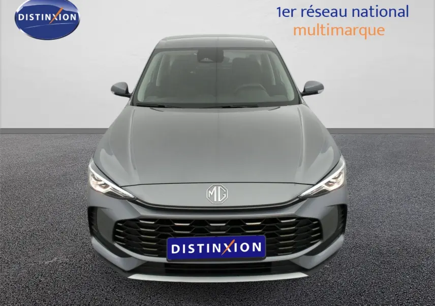 Vue avant d'un MG ZS 1.5 L Hybrid+ 197 ch en gris Hampstead avec calandre noire et phares LED allumés.