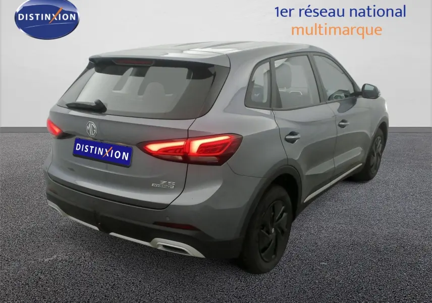 Vue 3/4 arrière droite d’un MG ZS hybride gris Hampstead avec feux arrière LED allumés et jantes acier 16 pouces.