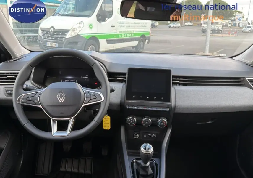 Vue intérieure avant de la Renault Clio gris foncé 2026, volant multifonction, écran tactile et levier de vitesse manuel visible.