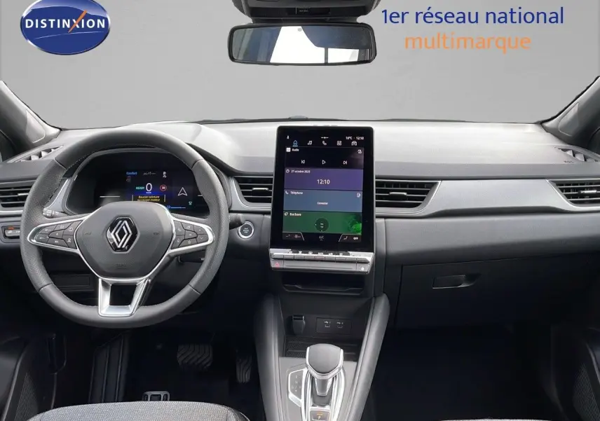 Intérieur du Renault Captur 2025 E-Tech hybride, vue frontale du tableau de bord avec écran tactile vertical et volant multifonction.
