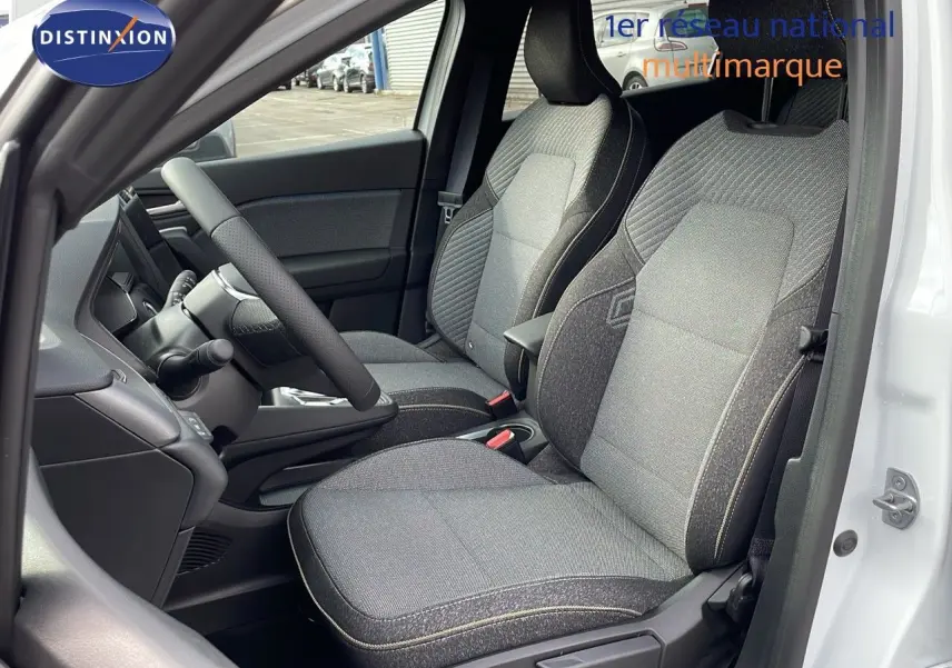 Intérieur côté conducteur du Renault Captur E-Tech hybride 2025 avec sièges tissu gris et volant noir, porte blanche ouverte.