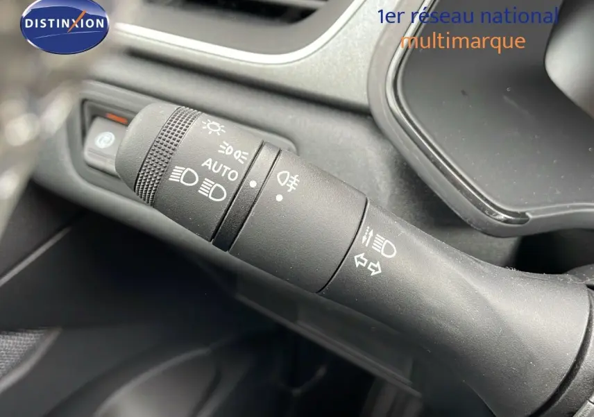 Gros plan sur la commande des phares et clignotants dans l'habitacle du Renault Captur blanc nacré toit beige 2025.