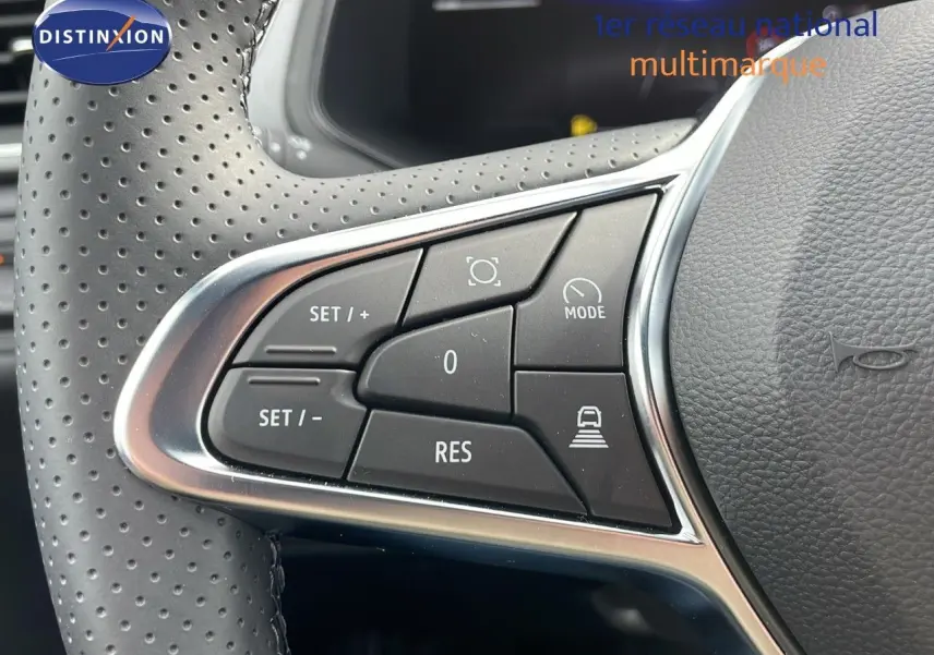 Gros plan sur les commandes au volant perforé du Renault Captur E-Tech hybride 2025, finition Technologie.