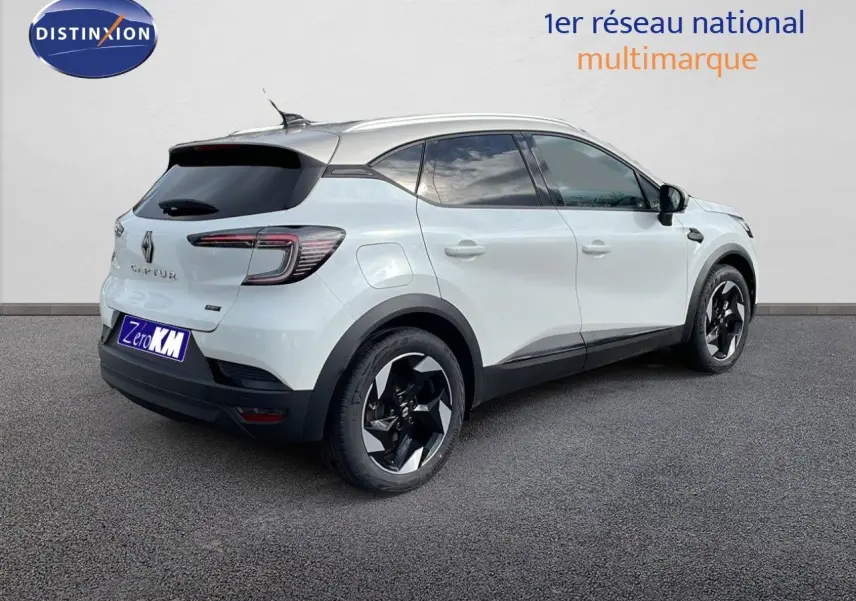 Vue 3/4 arrière droite d'un Renault Captur blanc nacré avec toit beige et jantes noires distinctives.