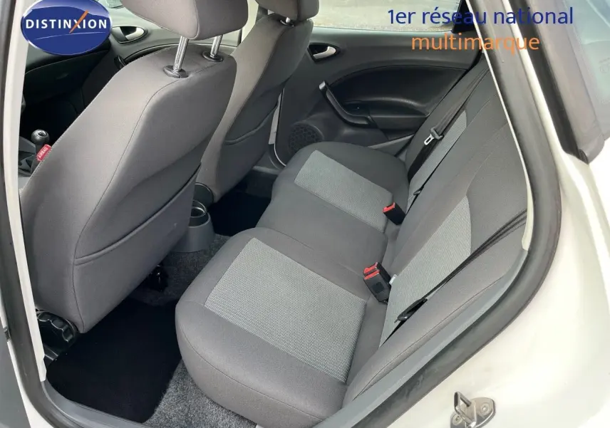 Vue intérieure arrière droite montrant les sièges arrière gris d'une SEAT Ibiza blanche 2010 1.6 TDI Style.