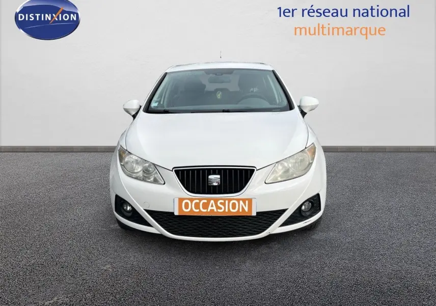 Vue de face d'une SEAT Ibiza blanche 1.6 TDI 90CH STYLE de 2010 avec plaque "OCCASION" sur un sol gris.