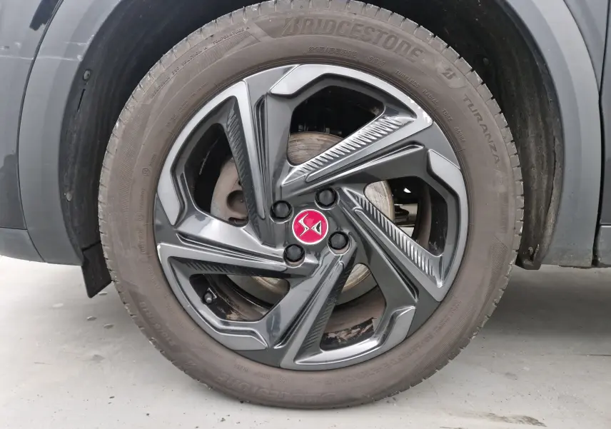 Gros plan sur la roue avant droite noire du DS3 Crossback 2019 avec jante alliage au logo DS rouge.