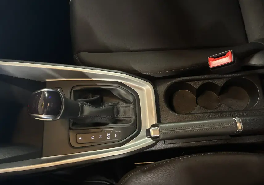 Gros plan sur la console centrale de l'Audi A1 2022, montrant levier de vitesse automatique et frein à main cuir.