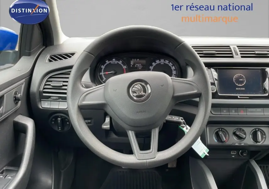 Gros plan sur le réglage des rétroviseurs côté gauche et la ventilation intérieure noire d'une Skoda Fabia bleu énergie.