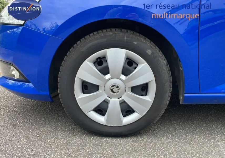 Vue plongeante sur l’intérieur côté conducteur d’une Skoda Fabia bleu énergie 2019 avec siège tissu noir ouvert.