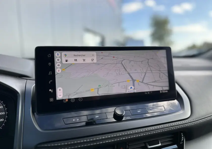 Écran tactile central affichant la navigation GPS dans l'habitacle du Nissan Qashqai blanc nacré.