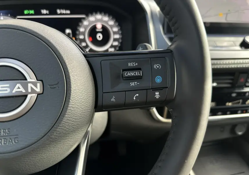 Gros plan sur le volant cuir noir du Nissan Qashqai 2025 avec commandes de régulateur de vitesse et assistance au conducteur.