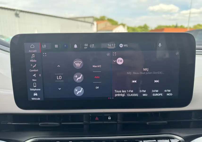 Écran tactile central de la Fiat 500 électrique 2022 affichant la climatisation et la radio FM NRJ.