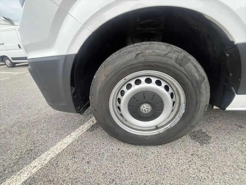 Gros plan sur la roue avant droite blanche d'un Volkswagen Crafter Fourgon L3H3 Business Line 2019 avec jante acier et logo VW.
