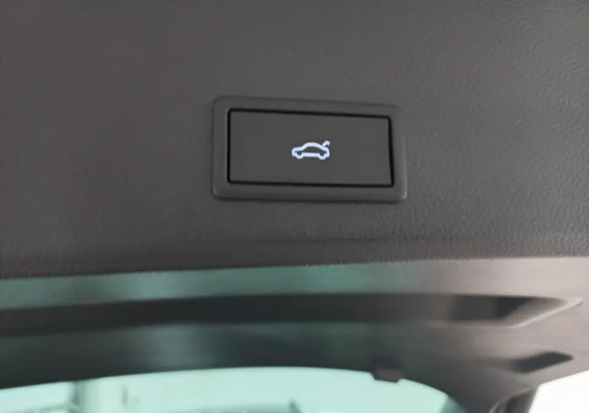 Bouton d'ouverture électrique du hayon sur le coffre d'un SEAT Ateca noir Magic Nacré 2025, vue intérieure arrière.