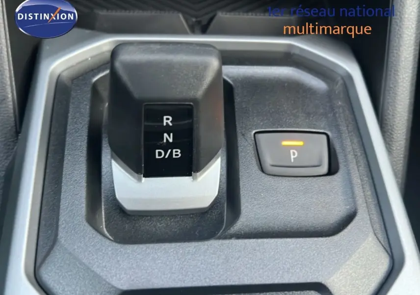 Gros plan sur la commande de boîte automatique et frein de parking électrique du Dacia Duster Hybrid 140 blanc Glacier.