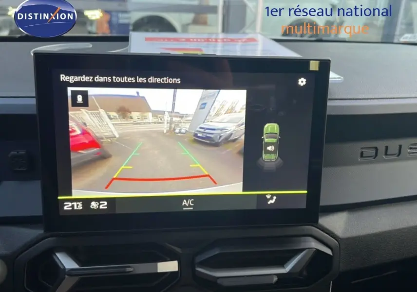 Écran central affichant la caméra de recul du Dacia Duster Hybrid 140 Journey, tableau de bord noir avec logo Duster visible.