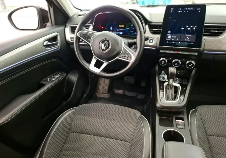 Intérieur noir du Renault Arkana 2022, vue du poste de conduite avec volant multifonction et écran tactile central.