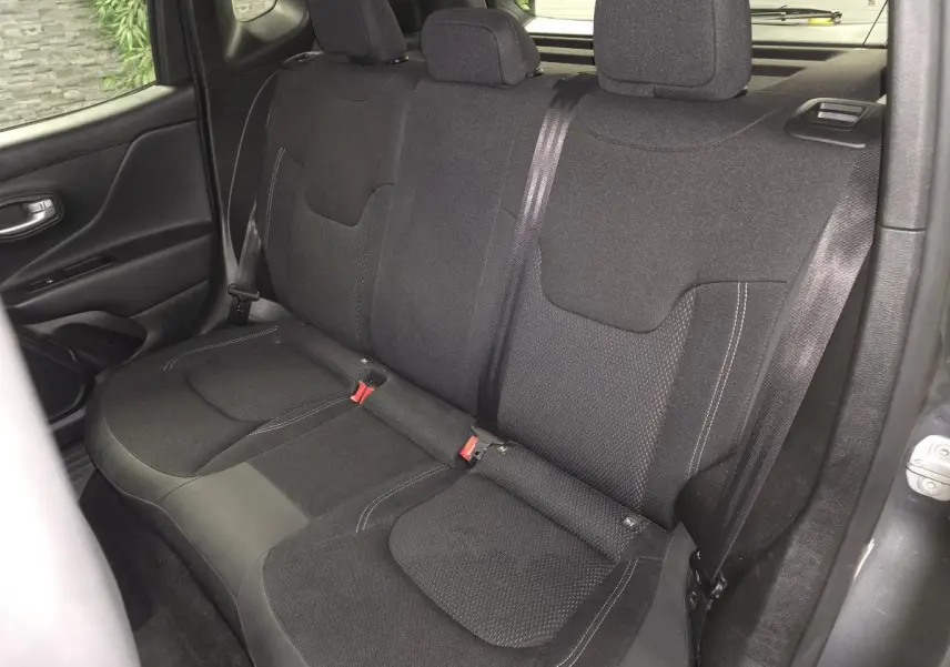 Vue intérieure du siège arrière en tissu noir du Jeep Renegade 2024, avec ceintures de sécurité visibles.
