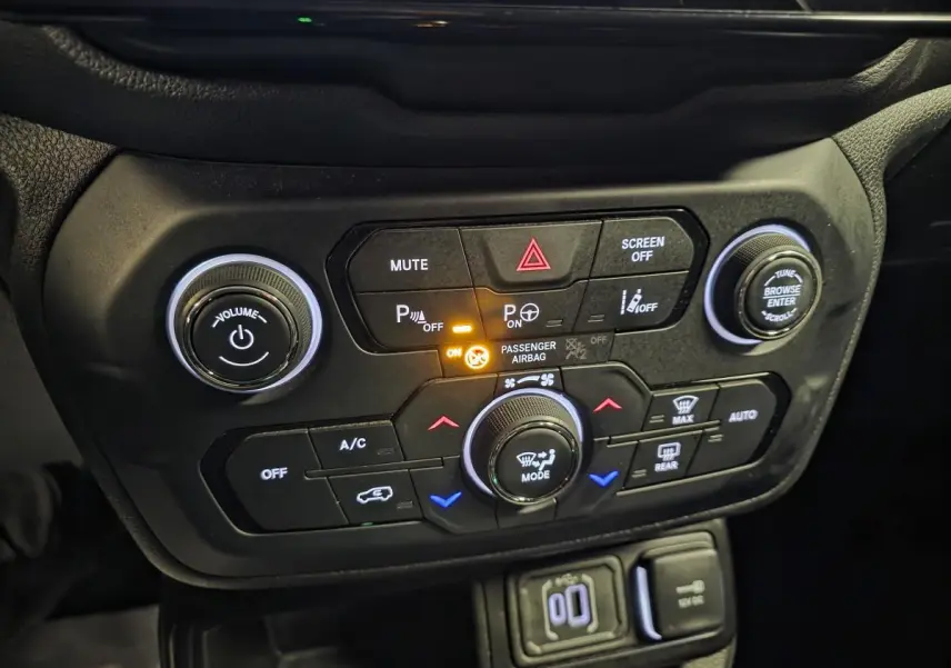 Panneau de commande central noir du Jeep Renegade 2024 avec boutons de climatisation et aides au stationnement allumés