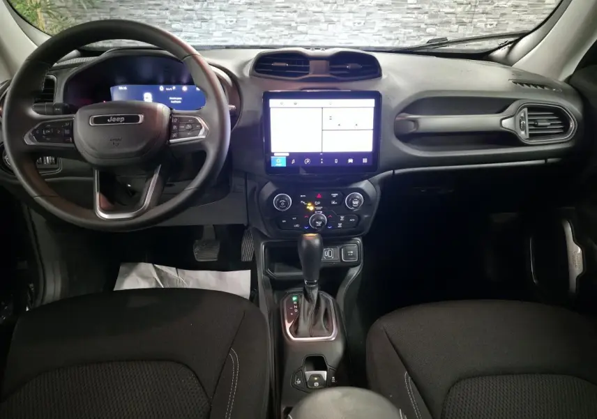 Vue frontale de l'intérieur du Jeep Renegade 2024 avec tableau de bord numérique et sellerie noire.