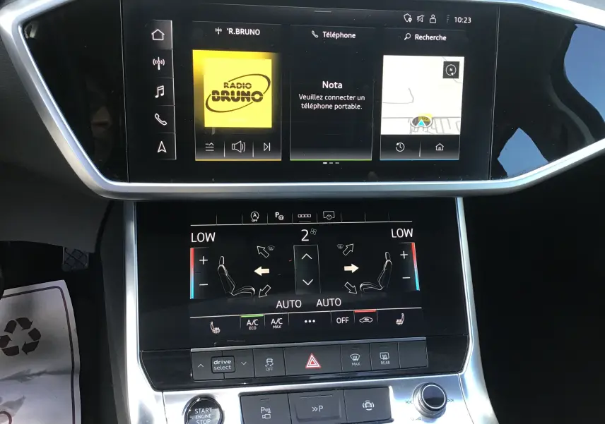 Vue rapprochée de l’écran tactile central et de la console de l’Audi A6 Avant 2022, affichant la climatisation et la radio.