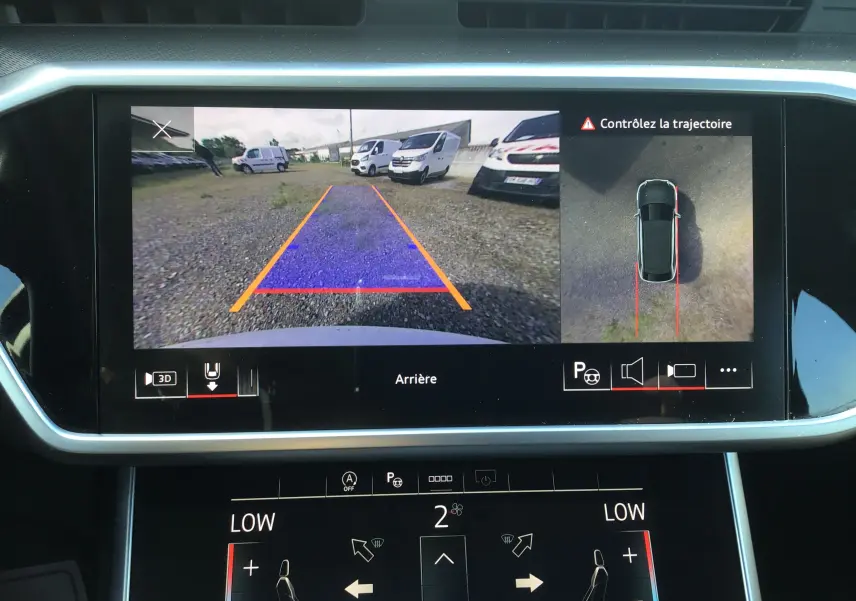 Écran central de l’Audi A6 Avant blanc glacier 2022 montrant la caméra de recul et l’aide au stationnement en vue arrière.