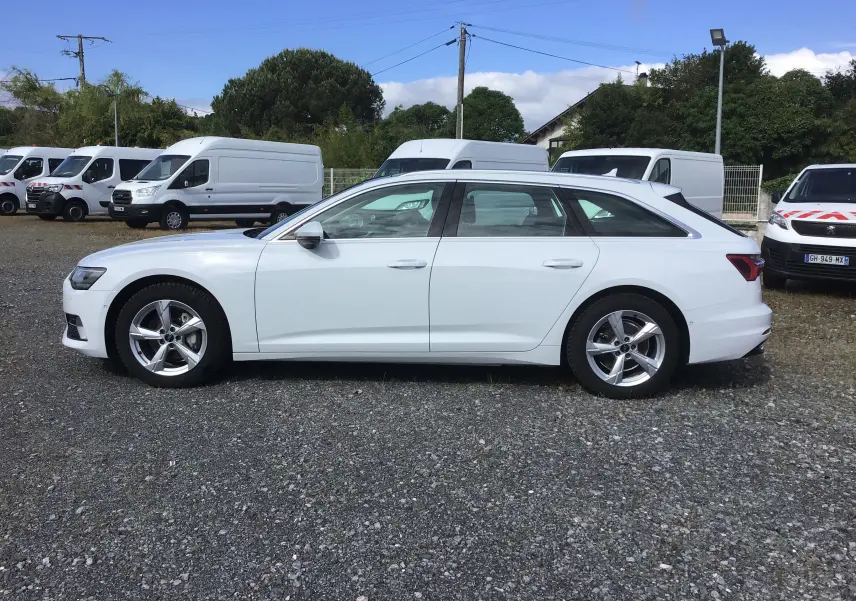 Audi A6 Avant blanc glacier vue de profil côté gauche, avec jantes alliage 5 branches et arrière distinctif.