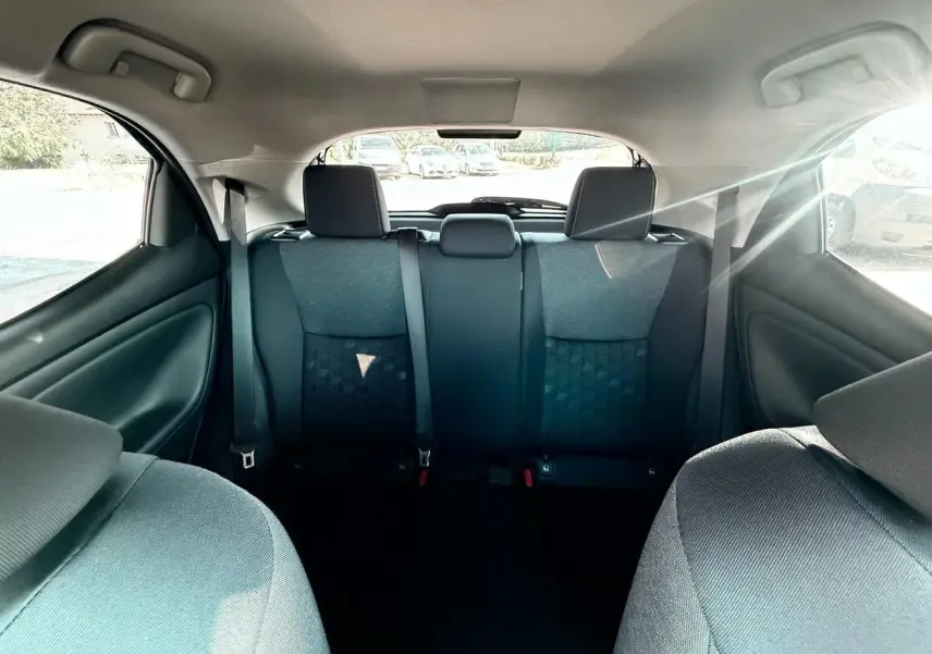 Vue intérieure arrière de la Toyota Yaris Hybrid 116ch 2025, montrant les sièges arrière en tissu gris foncé.
