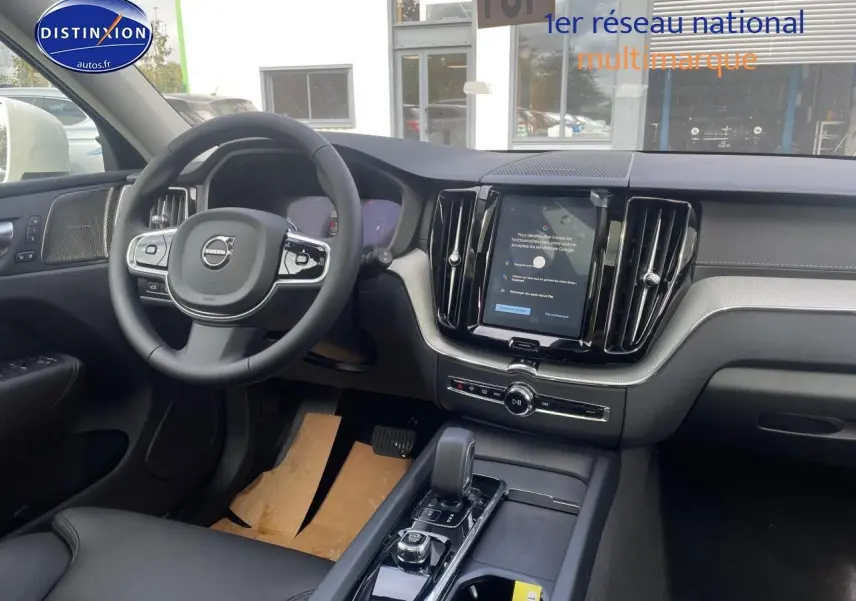 Intérieur avant du Volvo XC60 gris 2024, vue côté conducteur sur tableau de bord et console centrale moderne.