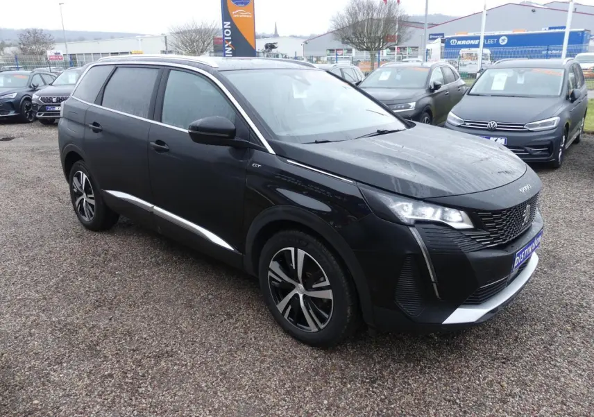 Peugeot 5008 GT noir métallisé vue 3/4 avant droit avec jantes bi-ton et calandre chromée distinctive.