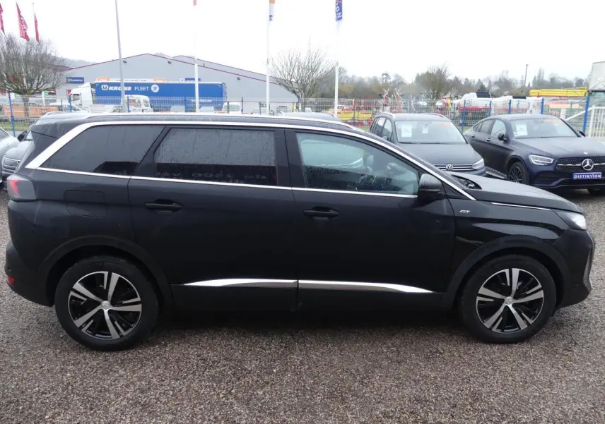 Profil côté gauche d'un Peugeot 5008 GT noir métallisé avec jantes alliage bicolores et vitres arrière surteintées.