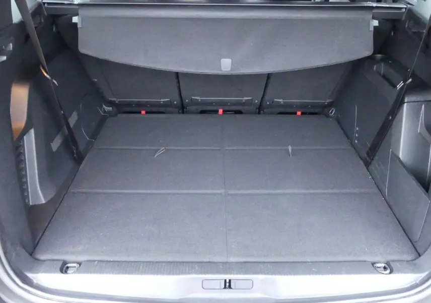 Coffre ouvert du Peugeot 5008 GT 2023 noir métallisé, montrant l'espace de chargement avec banquette arrière rabattue.