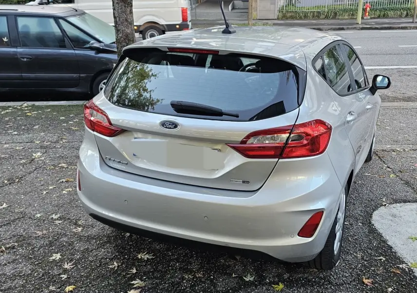 Vue 3/4 arrière droite d'une Ford Fiesta gris lunaire métal 2021 avec feux arrière et hayon visibles.