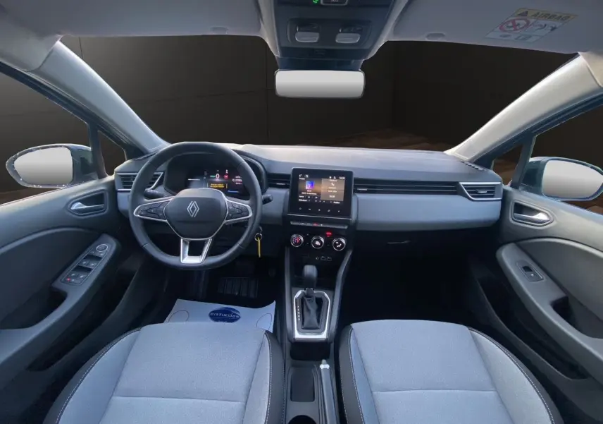 Vue intérieure avant de la Renault Clio V E-Tech gris schiste, avec tableau de bord moderne et écran tactile central.
