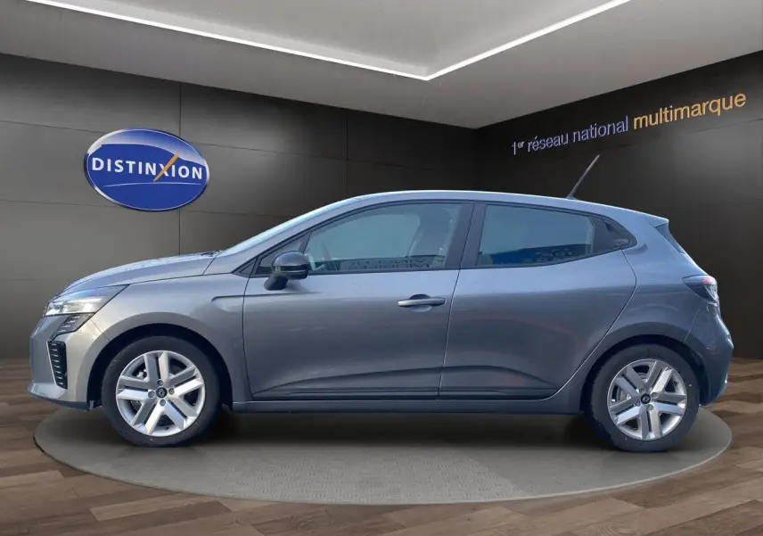 Vue de profil côté gauche d'une Renault Clio V gris schiste avec jantes alliage et antenne sur le toit dans un showroom.