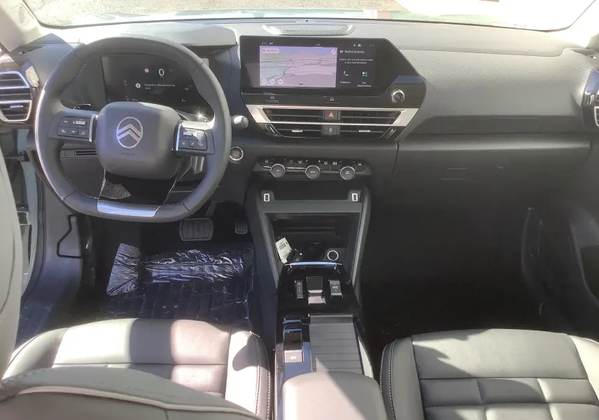 Vue intérieure avant du poste de conduite du Citroën C4 Hybrid 145ch avec écran tactile et volant multifonction noir.