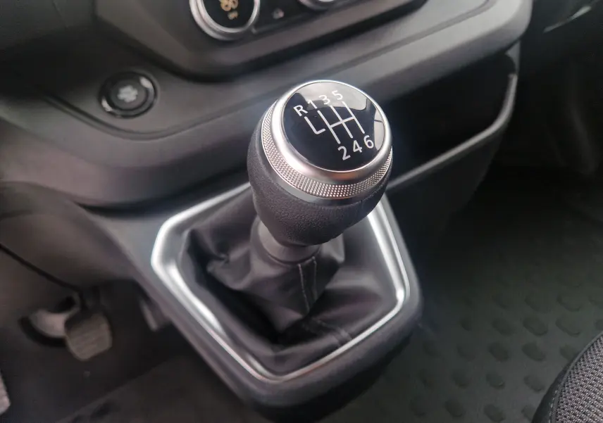 Le levier de vitesses manuel noir du Renault Trafic Fourgon L1H1 2025, avec console et pédales visibles.