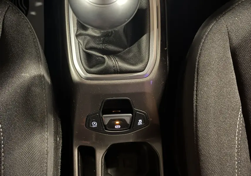 Vue plongeante sur la console centrale noire d'un Jeep Renegade 2019, mettant en valeur le levier de vitesse manuel et les commandes électroniques.