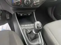 Gros plan sur la console centrale et levier de vitesse manuel de la Hyundai i20 2025 en tissu noir, intérieur sobre.