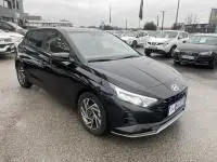 Vue 3/4 avant droite d'une Hyundai i20 2025 noire Phantom Metal avec jantes alliage et feux LED allumés.