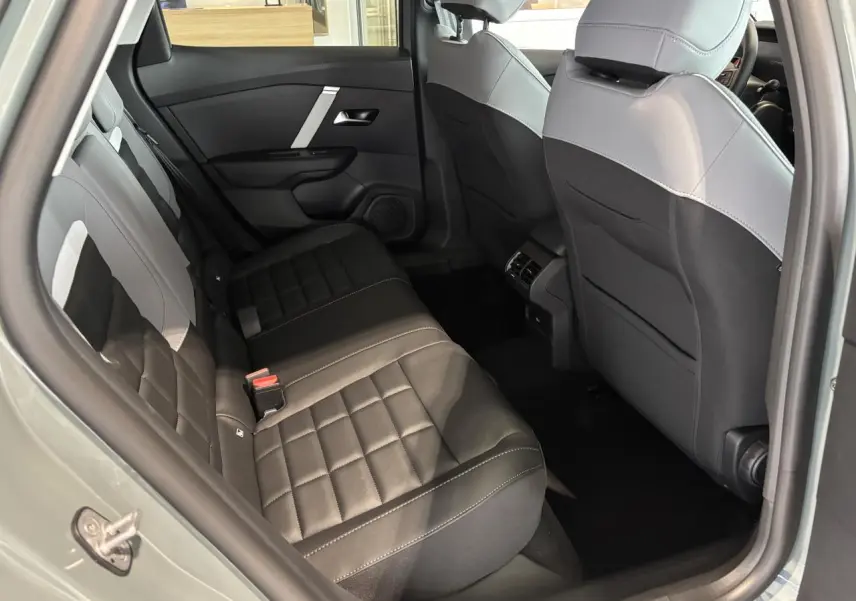 Vue intérieure arrière côté gauche de la Citroën C4 2026 avec sièges tissu noir et gris clair.