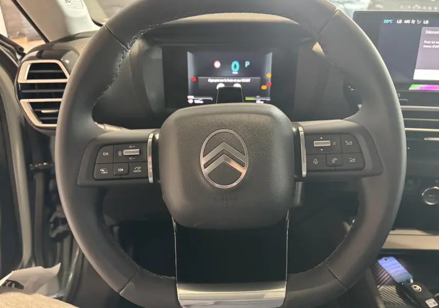 Volant cuir multifonctions Citroën C4 2026 vu de face, avec tableau de bord numérique et commandes intégrées.