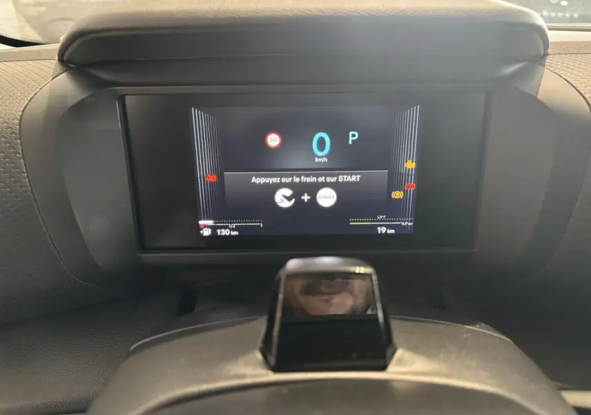 Vue rapprochée du tableau de bord numérique de la Citroën C4 hybride affichant un message de démarrage.