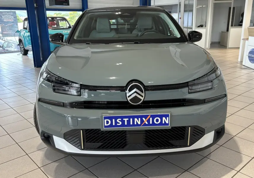 Vue frontale d'une Citroën C4 1.2i Hybride 2026 en vert Manhattan avec toit noir et détails noirs brillants.