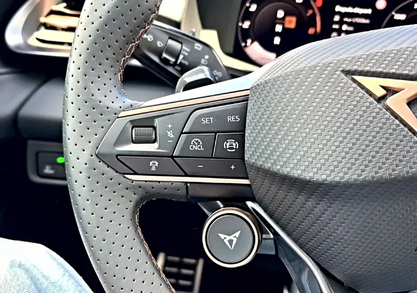 Gros plan sur le volant cuir perforé de la CUPRA Terramar 2026 avec commandes multifonctions et logo cuivre.